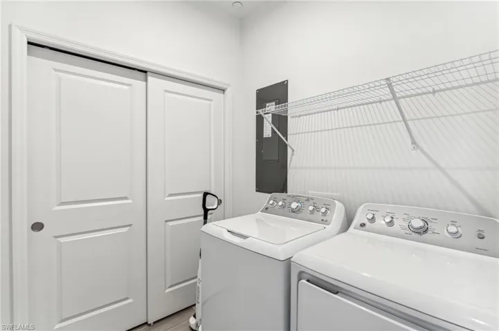 Laundry room with electric panel and independent washer and dryer