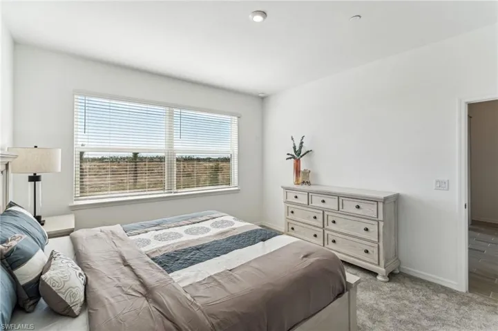 Bedroom featuring light colored carpet and baseboards