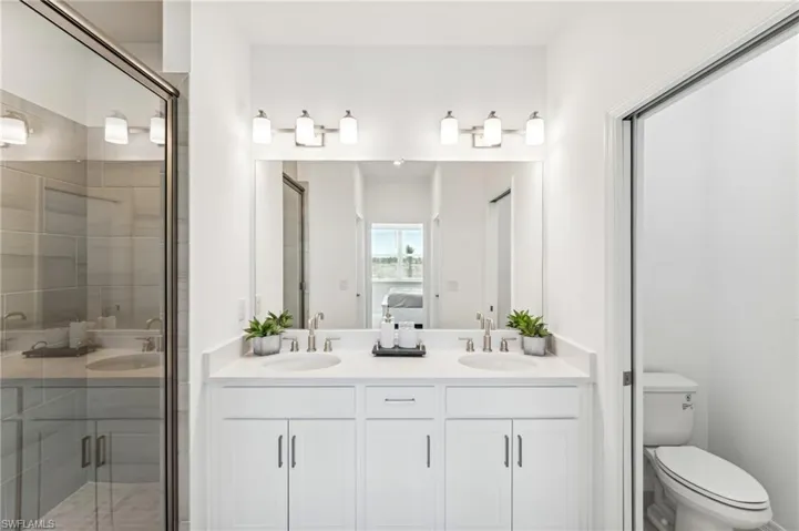 Full bath with double vanity, a stall shower, and ensuite bathroom