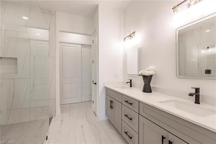 Bathroom with tile flooring, oversized vanity, and dual sinks