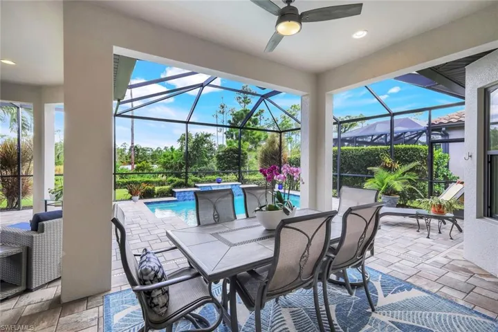 View of patio / terrace featuring a sunroom, a ceiling fan, a lanai, an outdoor pool, and outdoor dining area