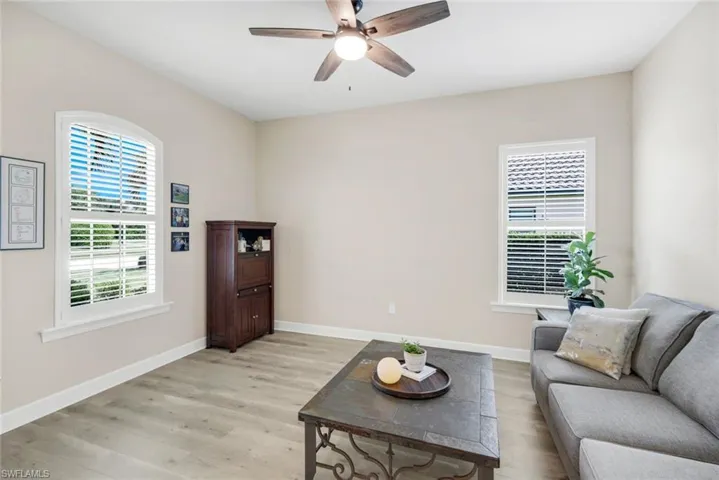Living area featuring light wood-style floors, healthy amount of natural light, and ceiling fan