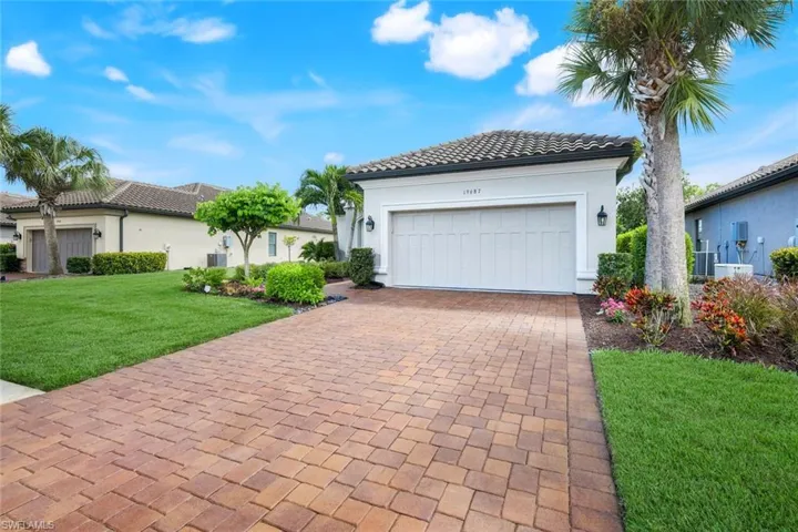 Mediterranean / spanish house featuring a front yard, decorative driveway, stucco siding, a tile roof, and a garage