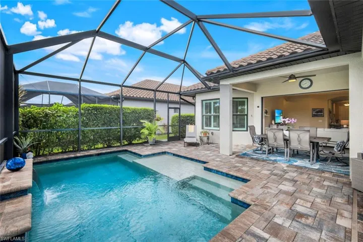 Swimming pool featuring a lanai, a sunroom, a patio, and outdoor dining space