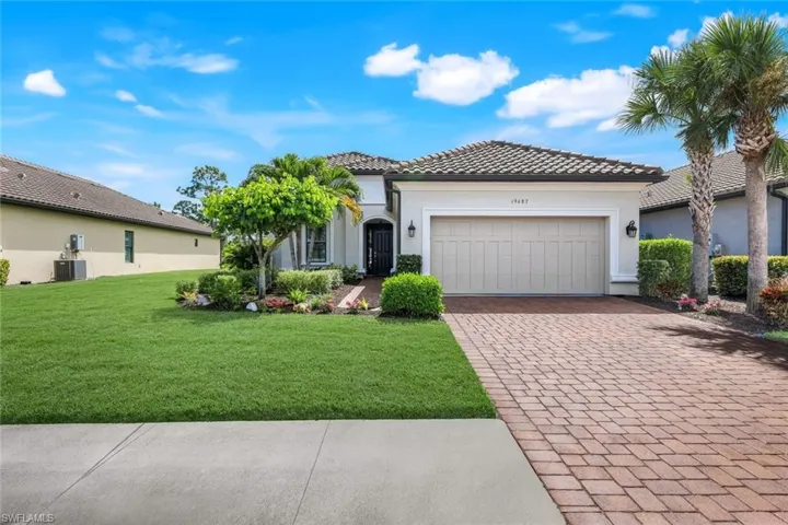 View of front of house featuring stucco siding, a front lawn, decorative driveway, an attached garage, and a tile roof