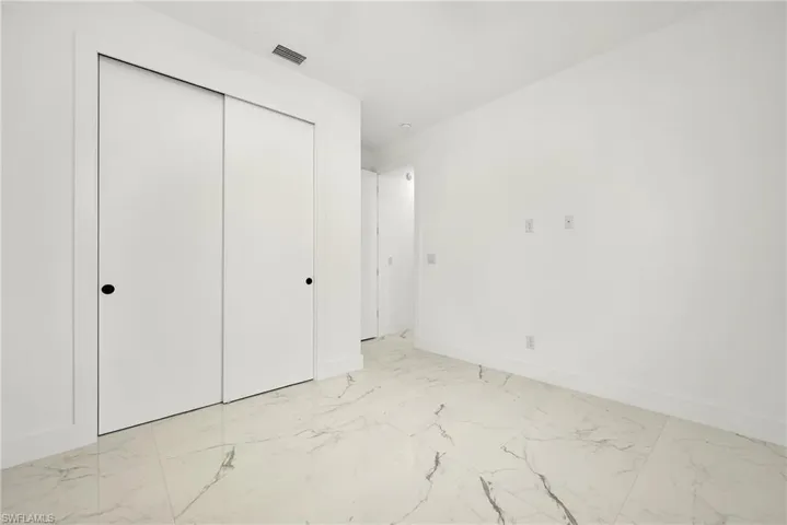 Unfurnished bedroom featuring light tile patterned flooring and a closet
