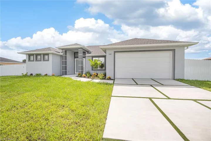 View of front of property featuring a garage and a front yard