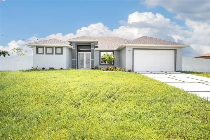 View of front facade featuring a garage and a front yard