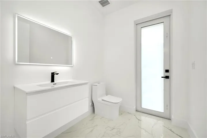 Bathroom featuring toilet, vanity, and tile patterned flooring