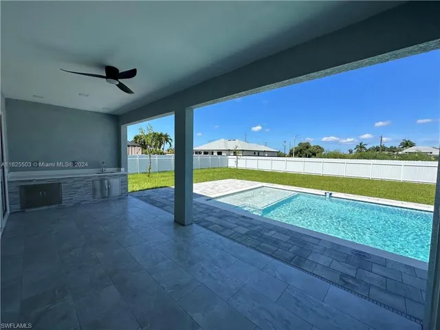 View of pool featuring area for grilling, sink, ceiling fan, and a patio area
