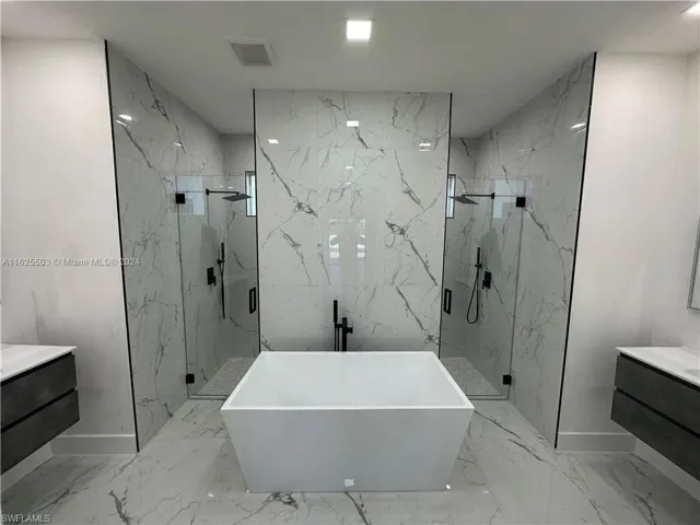 Bathroom with tile walls, vanity, separate shower and tub, and tile patterned flooring