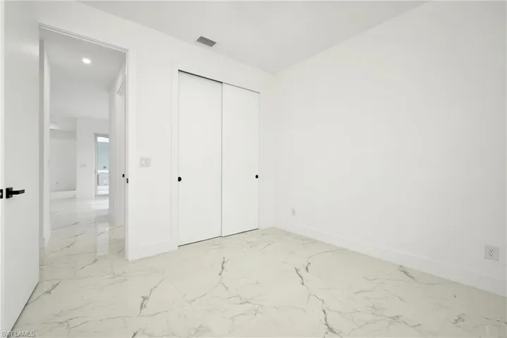Unfurnished bedroom featuring a closet and light tile patterned floors