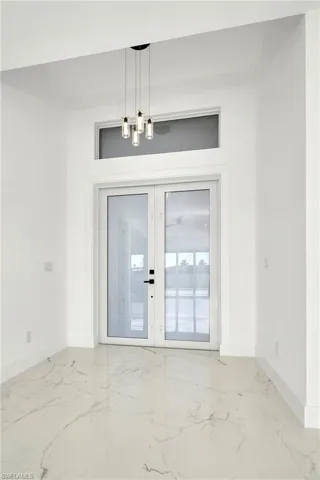 Tiled spare room with french doors