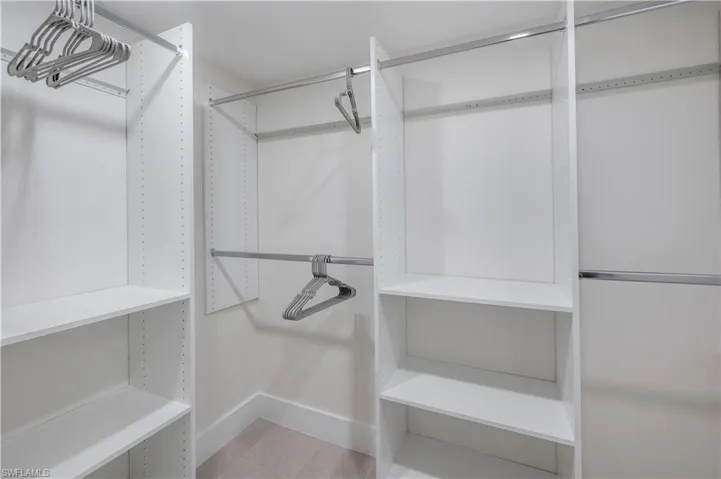Large walk-in closet with wall mirror