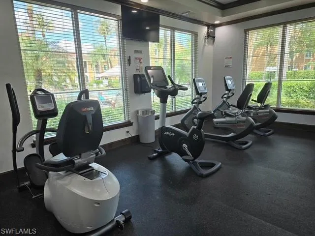 Gym with crown molding and a raised ceiling