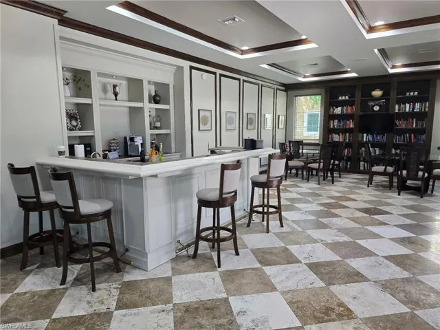 Bar area with crown molding, coffered ceiling, light countertops, and open shelves