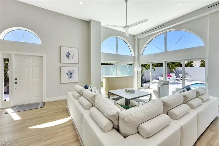 Living area featuring a high ceiling, wood finished floors, visible vents, and baseboards