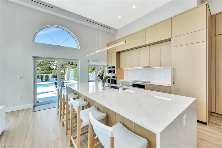 Kitchen featuring a sink, modern cabinets, cream cabinetry, and light wood finished floors