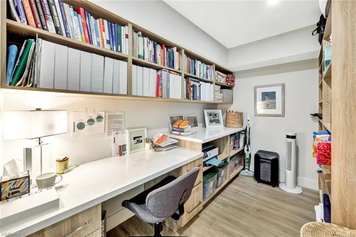 Home office with baseboards, light wood-style floors, and built in study area