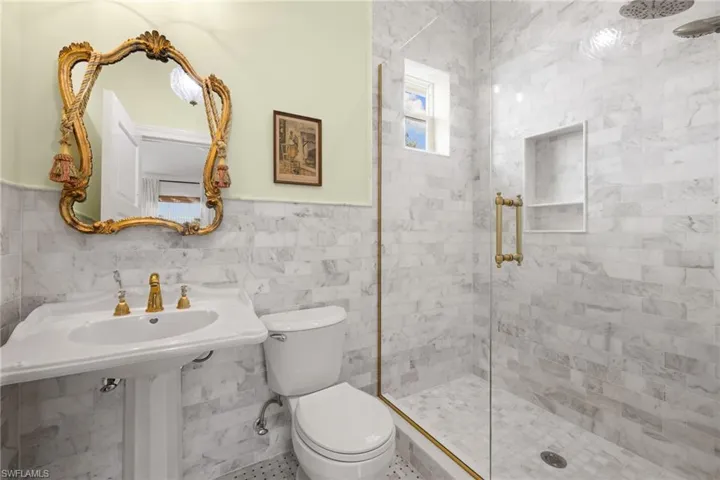Bathroom featuring tile walls and a stall shower