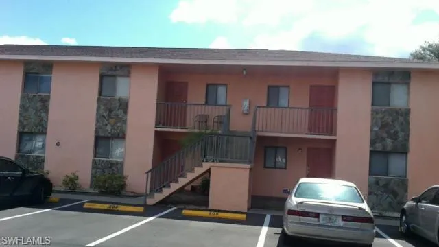 View of apartment building / complex with uncovered parking and stairs