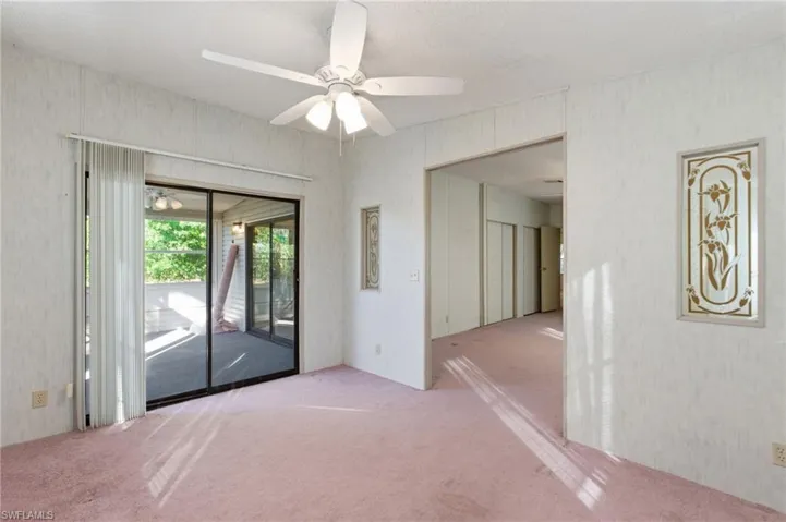 Carpeted spare room featuring a ceiling fan