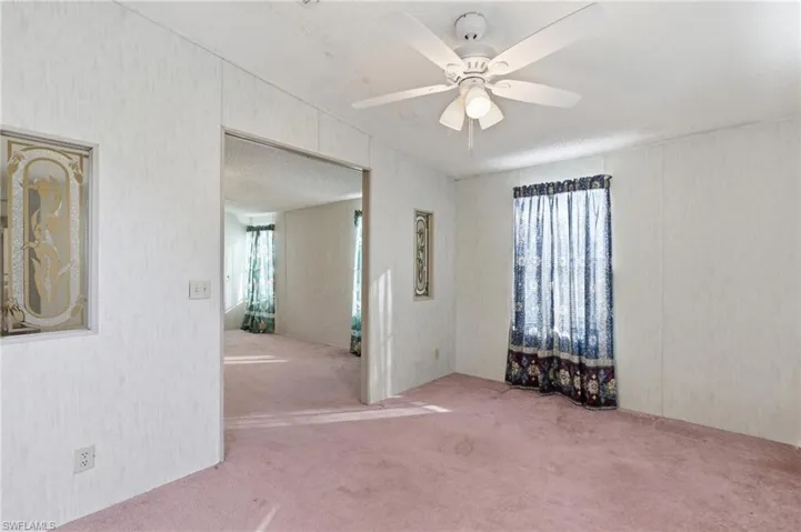 Spare room with carpet flooring, ceiling fan, and a textured ceiling