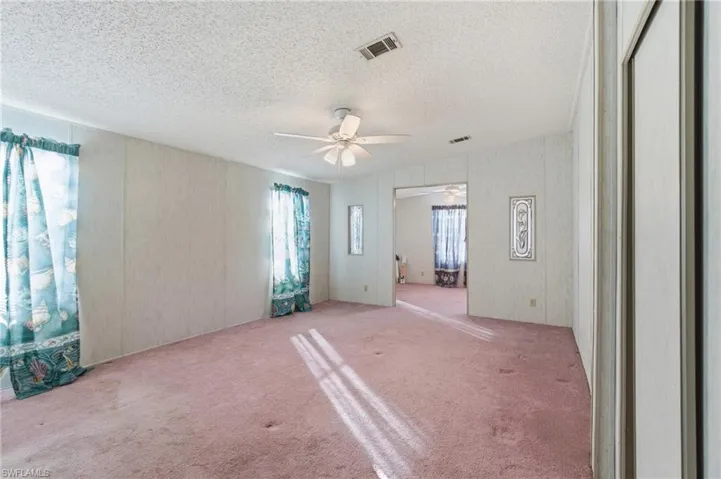 Carpeted spare room featuring a ceiling fan and a textured ceiling