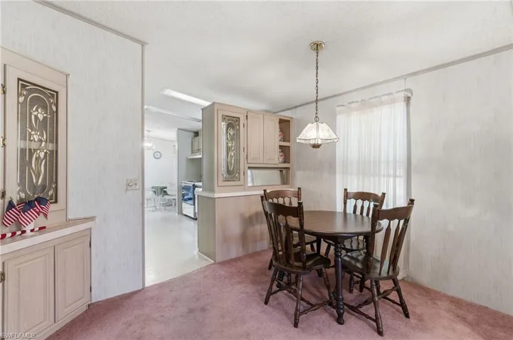 Dining area featuring a textured ceiling and light colored carpet