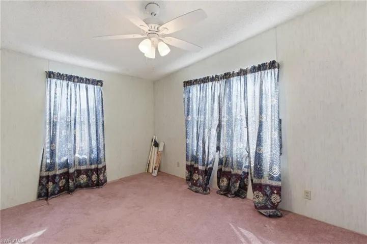 Empty room with carpet flooring and ceiling fan