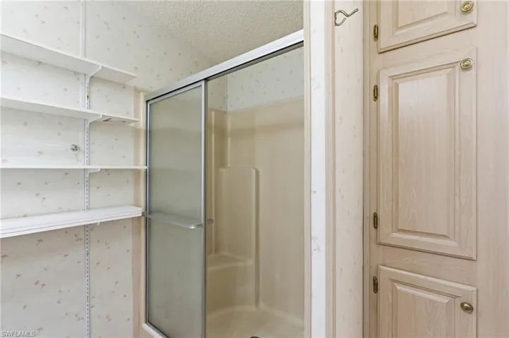 Bathroom featuring a stall shower and a textured ceiling