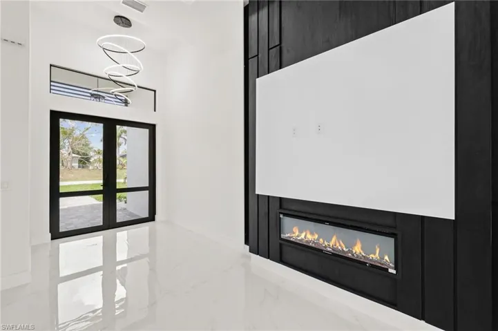 Entrance foyer featuring baseboards, marble finish floor, and a glass covered fireplace