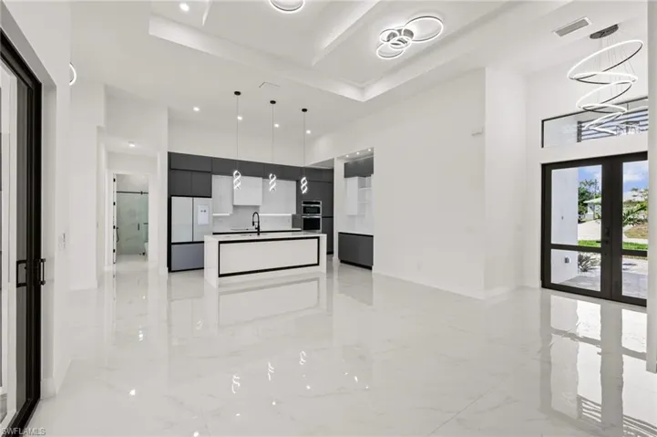Kitchen with modern cabinets, open floor plan, french doors, stainless steel refrigerator, and marble finish floor