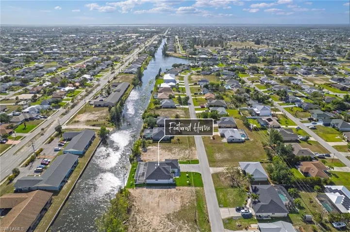 Birds eye view of property featuring a water view and a residential view