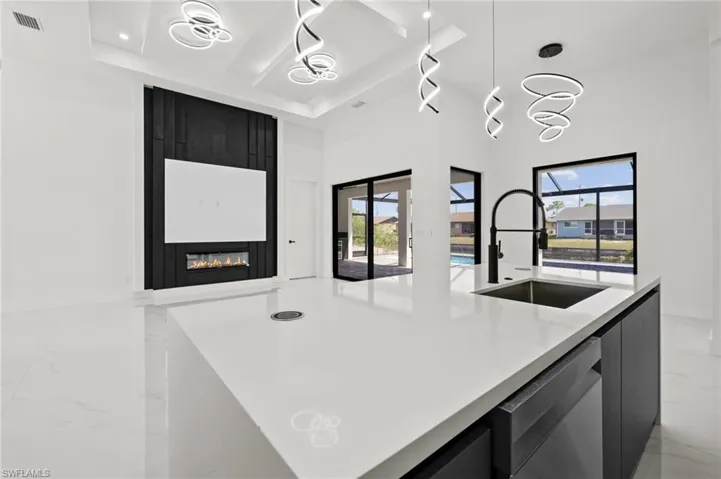 Kitchen with dishwasher, marble finish floor, a tray ceiling, and modern cabinets