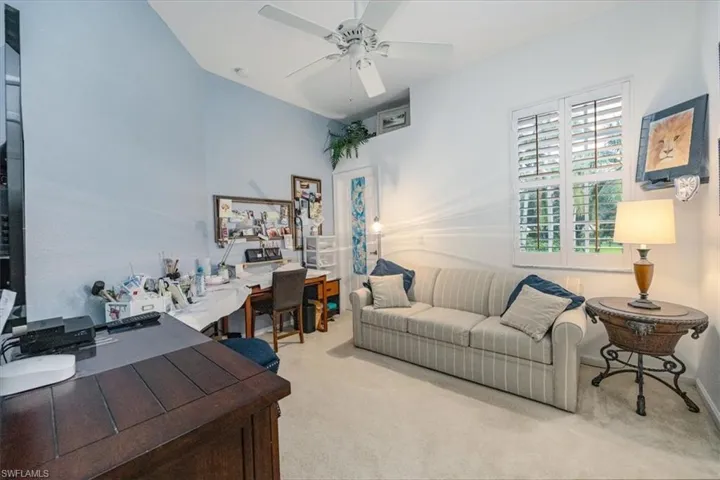 Carpeted home office featuring ceiling fan