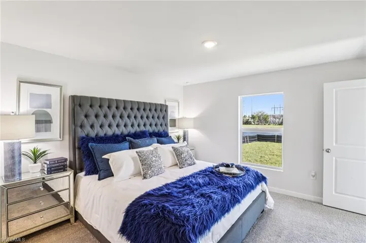 Model home. Carpeted bedroom featuring baseboards