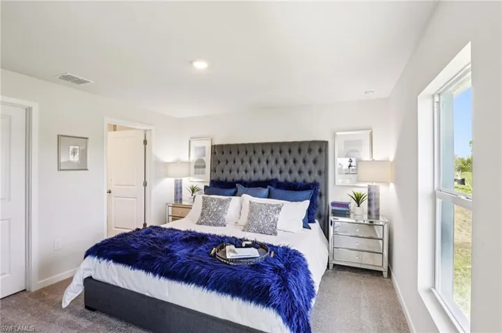 Model home. Carpeted bedroom featuring baseboards