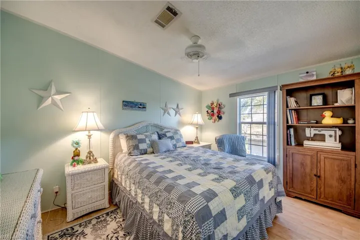 Bedroom featuring light wood-style flooring, ceiling fan, and a textured ceiling