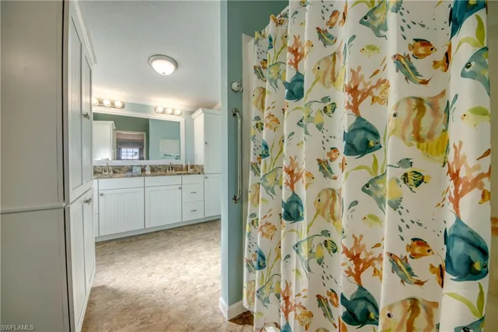 Full bathroom with vanity, curtained shower, and ornamental molding