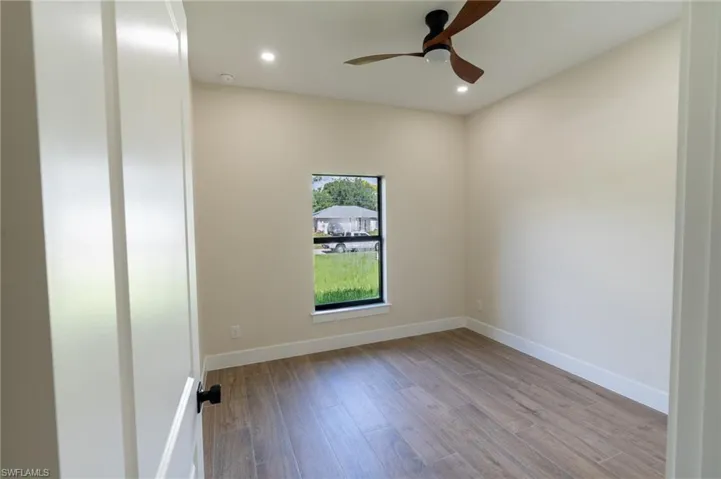 Room featuring wood-finish flooring, recessed lighting, and a contemporary ceiling fan