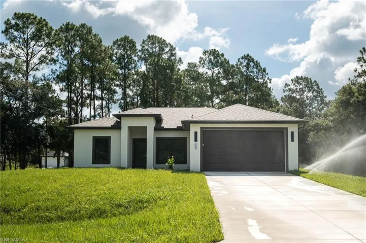 Single-story home featuring a stucco exterior with dark trim and a gabled roof