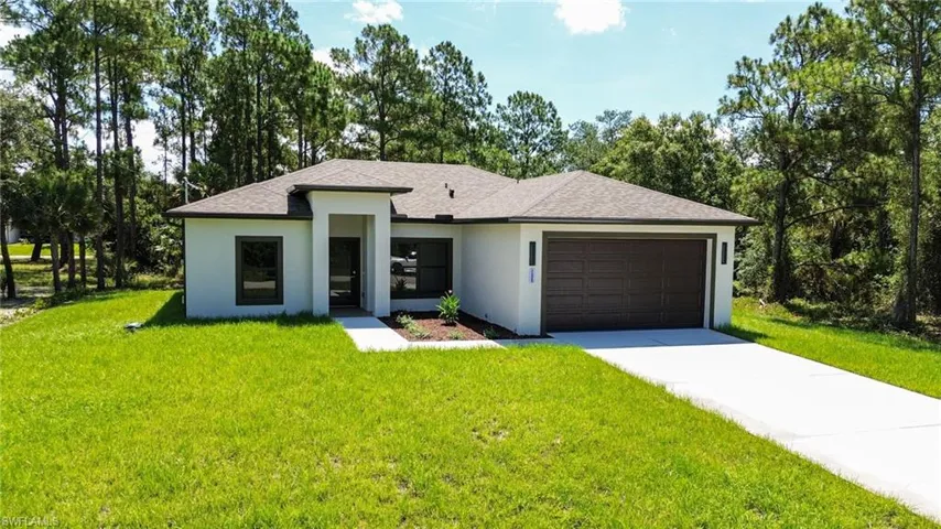 Contemporary single-story residence featuring a two-car garage, established landscaping, and a paved driveway