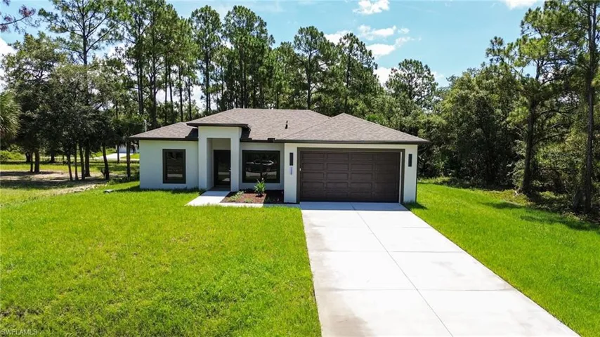 Contemporary single-story residence featuring a two-car garage, a concrete driveway, and a front entrance with an overhang