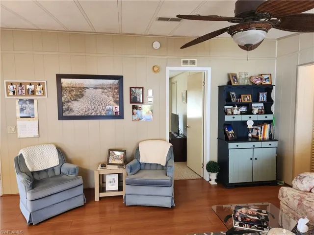 Living area with ceiling fan and hardwood / wood-style flooring
