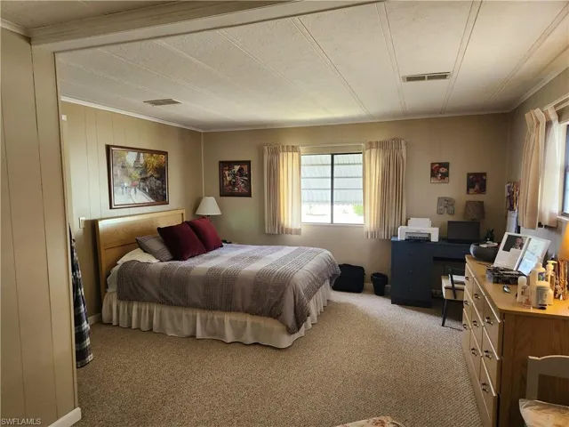 Carpeted bedroom with crown molding and a textured ceiling