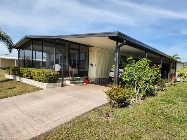 View of front of home featuring a front lawn and a carport