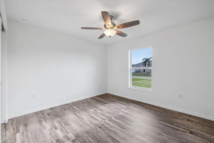 Empty room with ceiling fan and hardwood / wood-style floors