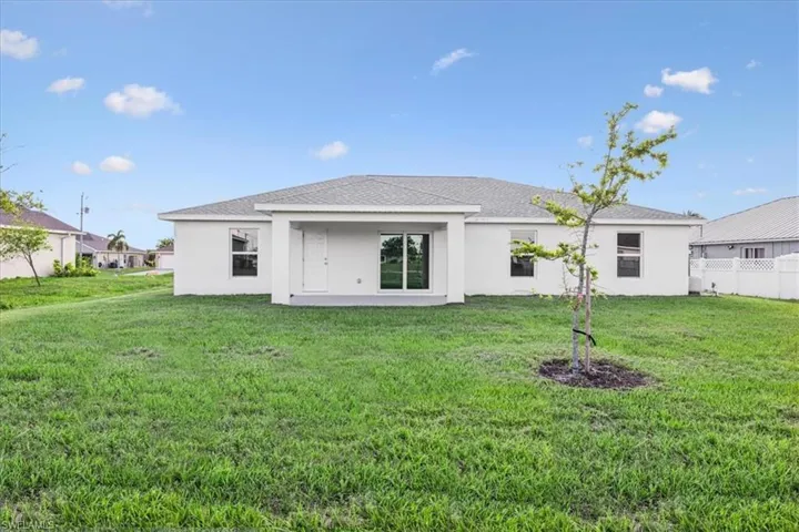 Back of house with a yard