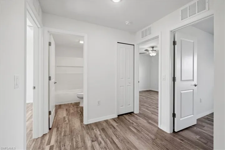 Hallway with hardwood / wood-style flooring